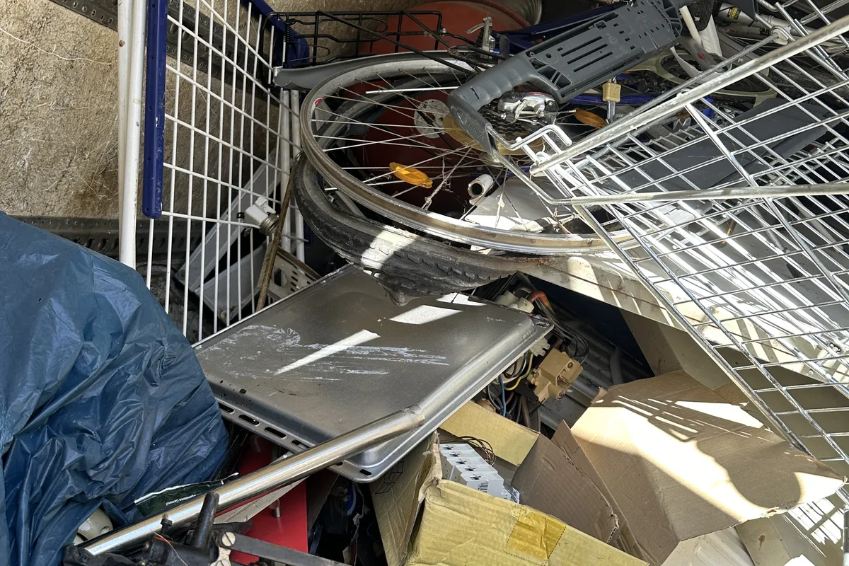 Gemischter Metallbestand mit Fahrradteilen, Regalen und Geräten in einer Garage